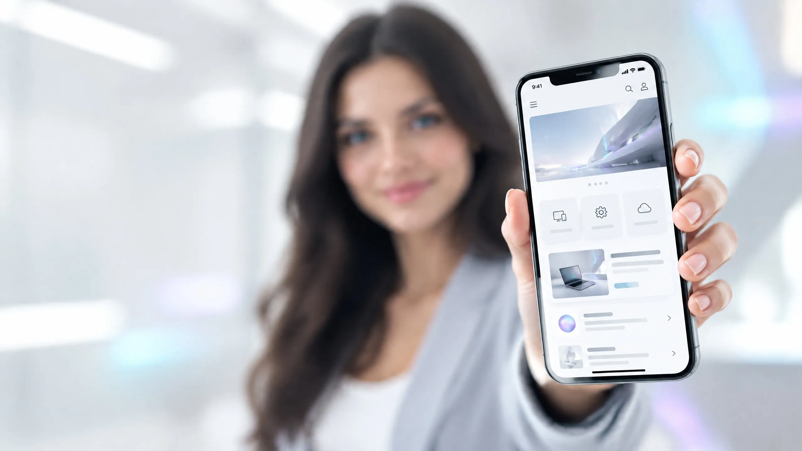 Frau in einem hellen Büro hält ein Smartphone in die Kamera, auf dessen Bildschirm eine Webseite mit Hamburger-Menü, Bildbereich und untereinander angeordneten Kacheln erscheint.